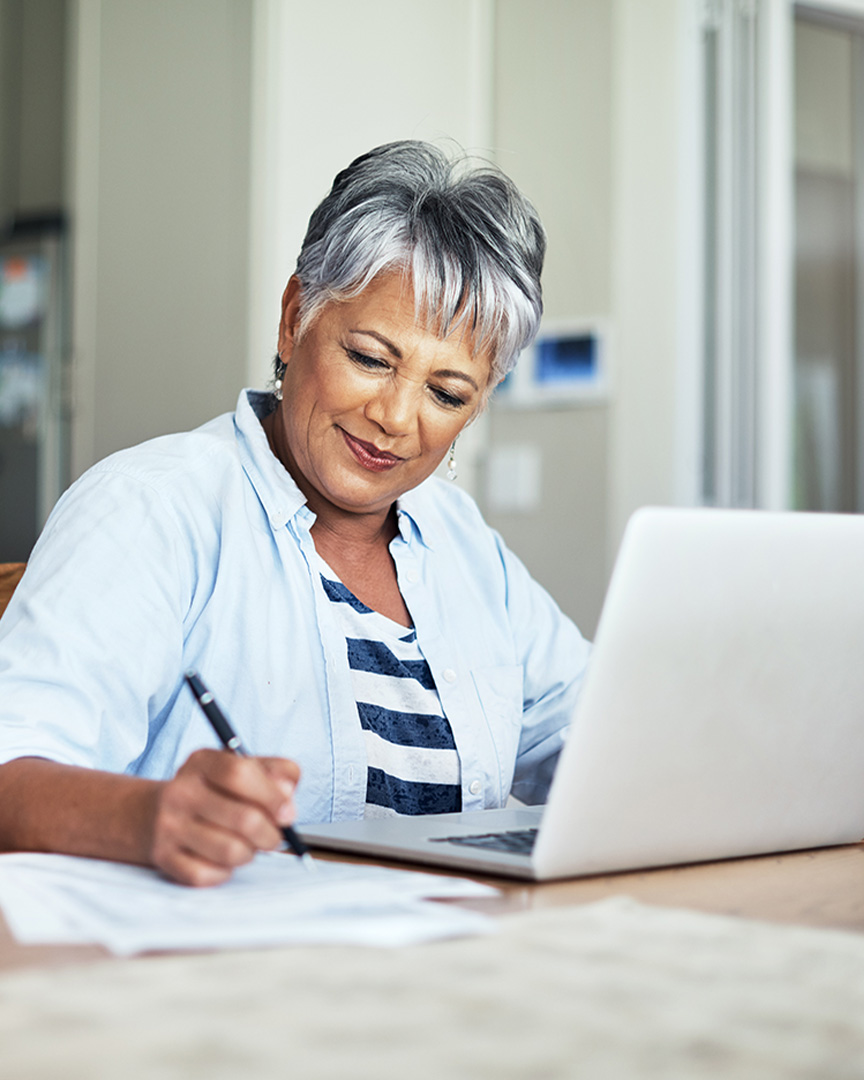 A person works on a laptop to apply online for Amerant's retirement savings to help prepare for the future.