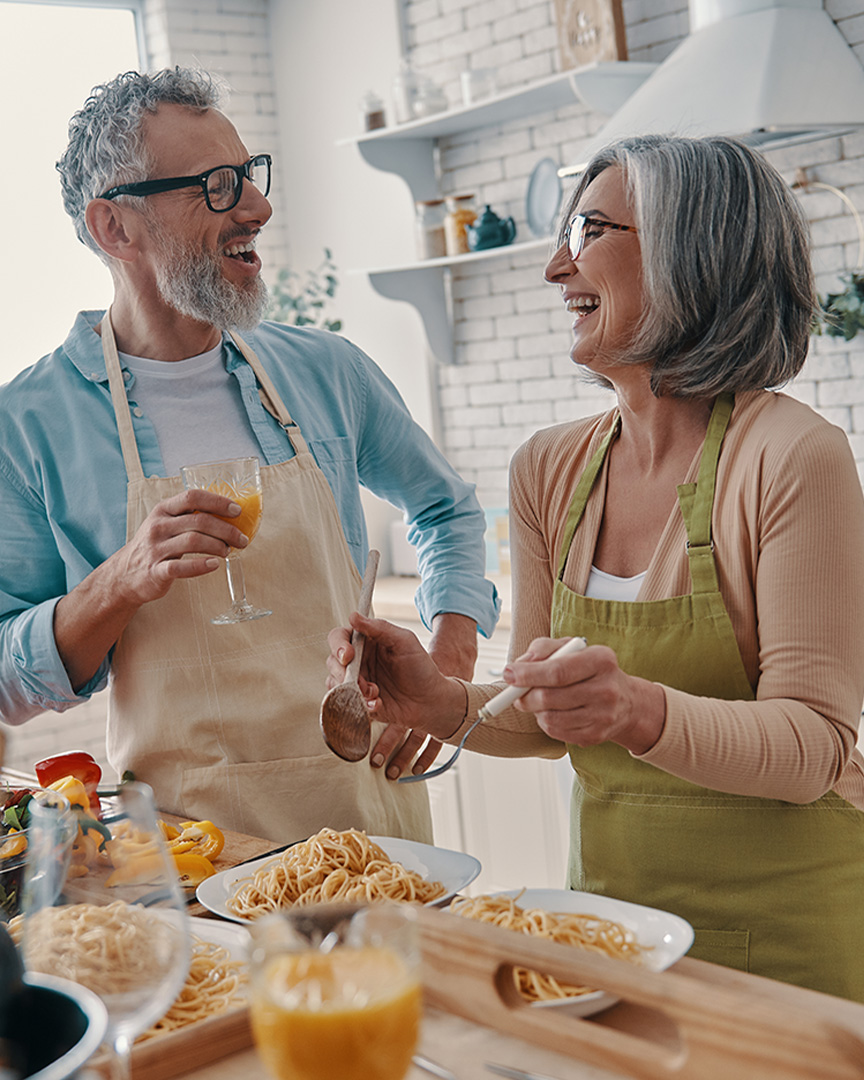 A couple celebrating cooking in a new kitchen with the benefits of their IRA savings.